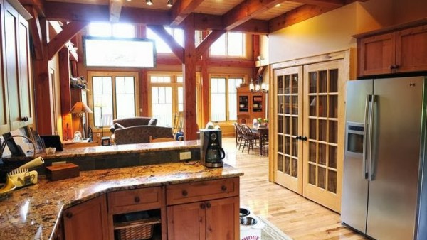 A kitchen with wood floors and wooden cabinets.